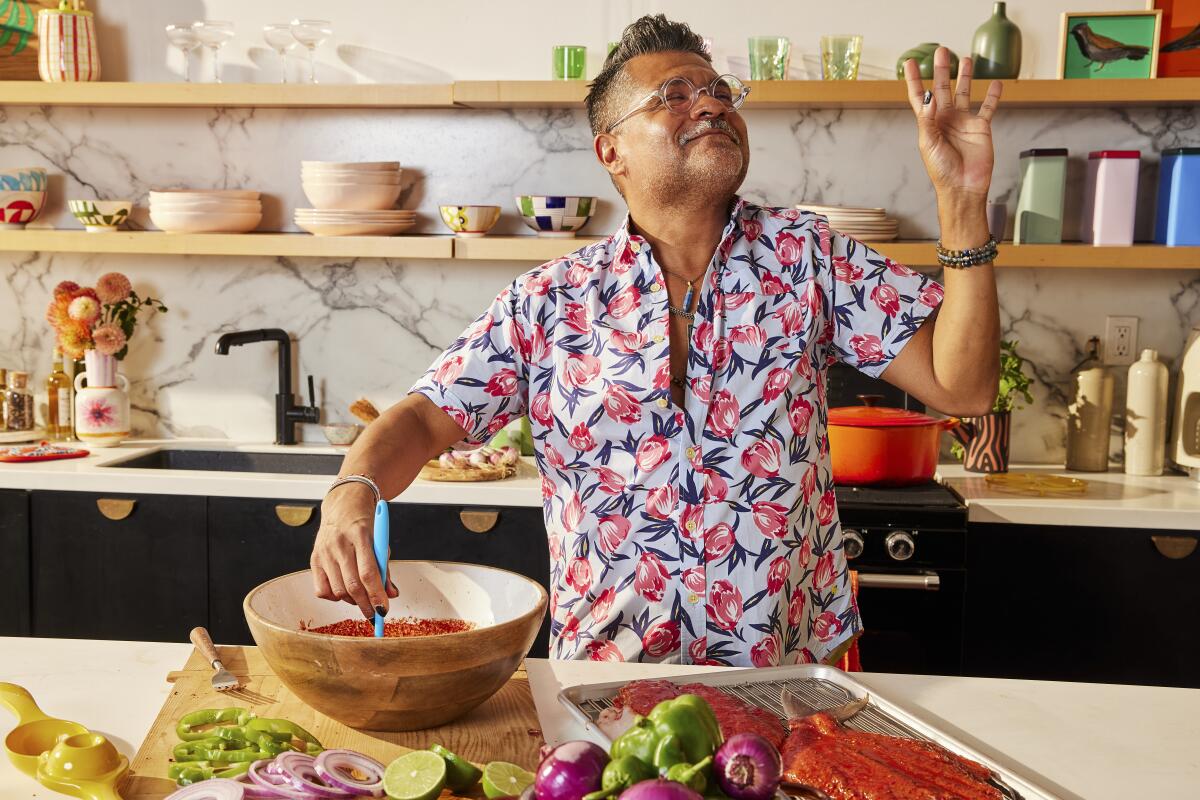 Rick Martinez dances to salsa music as he prepares an achiote paste for a red snapper.