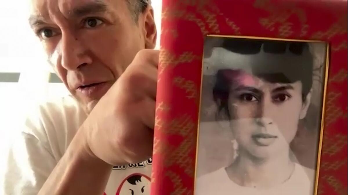 Kim Aris displaying an old family photo of his mother, Aung San Suu Kyi 