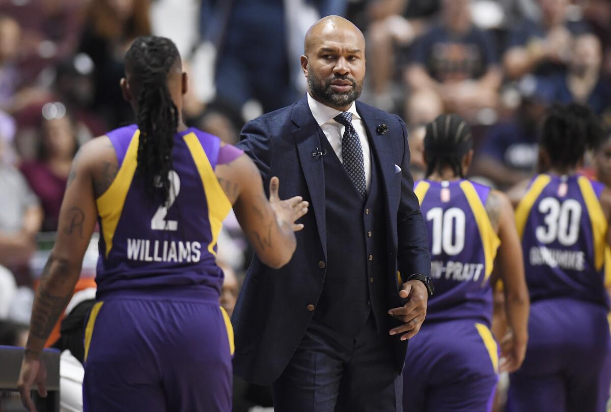 Sparks coach Derek Fisher greets guard Riquna Williams as she exits the court during the first half of a WNBA playoff game against the Sun on Sept. 17, 2019, in Uncasville, Conn.