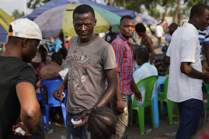 Supporters of Congolese President elect Felix Tshisekedi sell souvenirs outside his party headquarters in Kinshasa, Democratic Republic of the Congo, Wednesday Jan. 23, 2019. Tshisekedi is to be inaugurated Thursday Jan. 24, 2019, having won an election that raised numerous concerns about voting irregularities amongst observers as the country chose a successor to longtime President Joseph Kabila. (AP Photo/Jerome Delay)