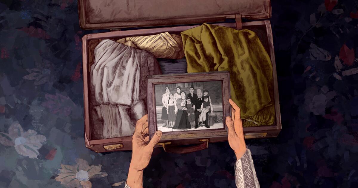 A woman's hands take a framed photo out of a suitcase.