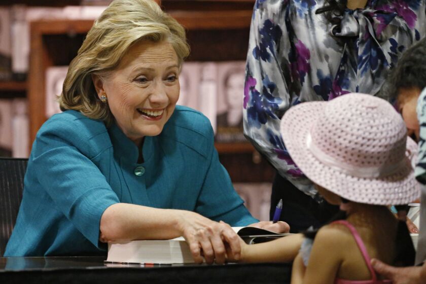 Hillary Rodham Clinton greets a young girl at a book signing in Denver on Monday.
