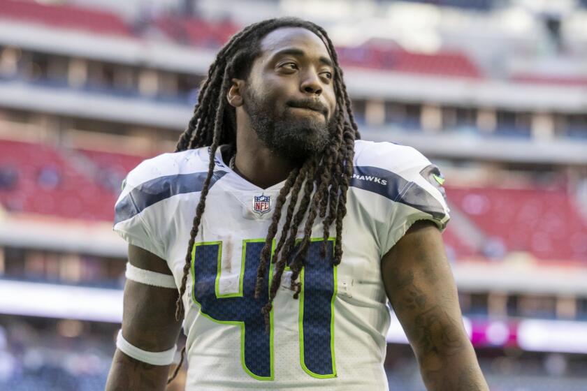 Running back (41) Alex Collins of the Seattle Seahawks walks off the field after defeating the Houston Texans.