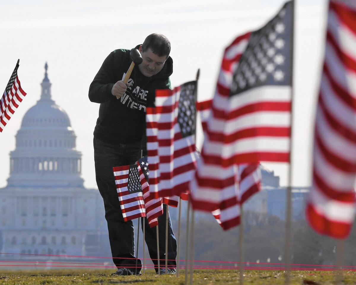 Army veteran David Dickerson helps place flags in March 2014 on the National Mall in Washington to represent the veterans and service members who died by suicide.