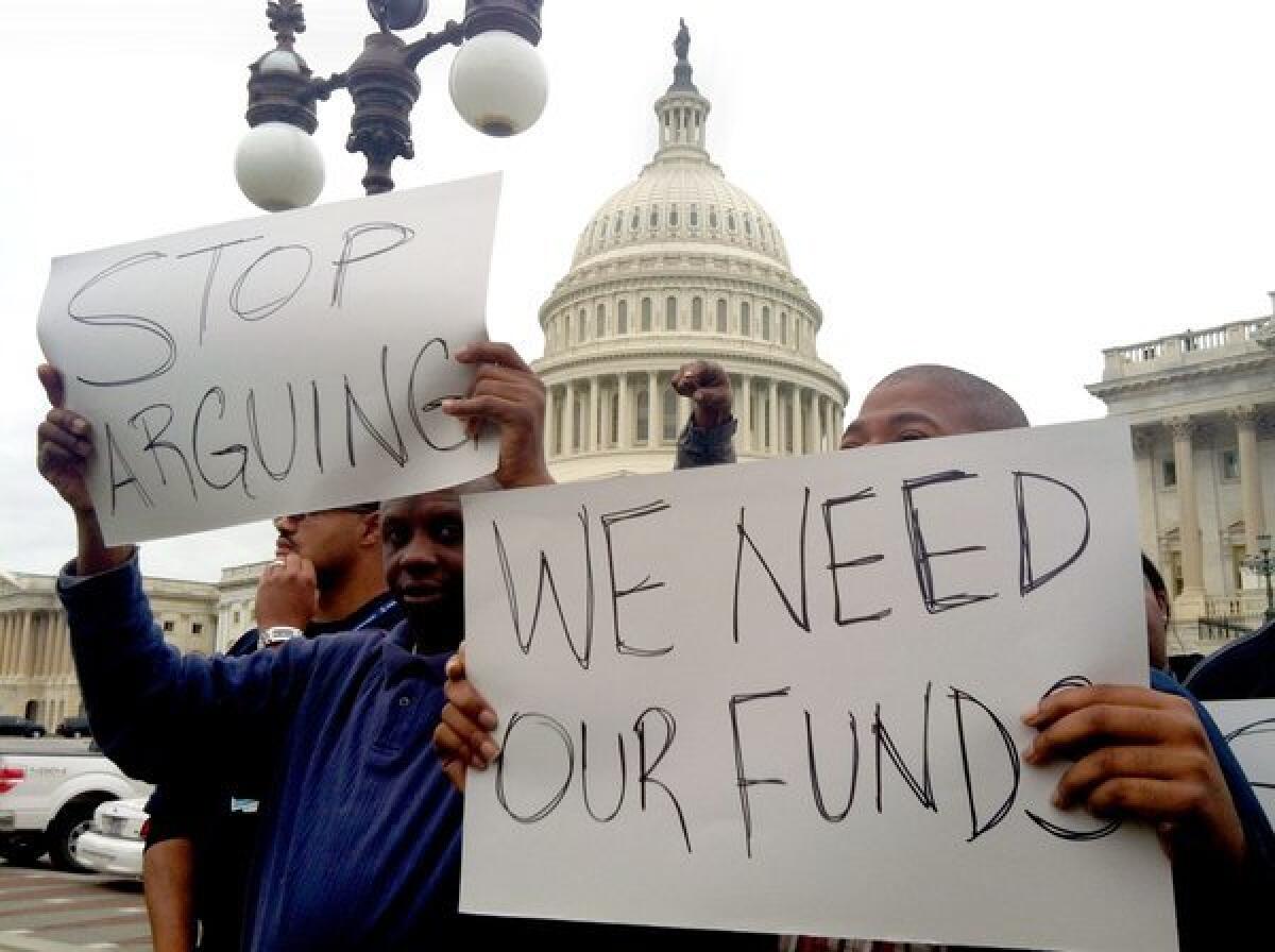 More contractors have announced furloughs due to the prolonged government shutdown. Above, protesters in Washington on Wednesday urged Congress to reopen government agencies and pass a budget.