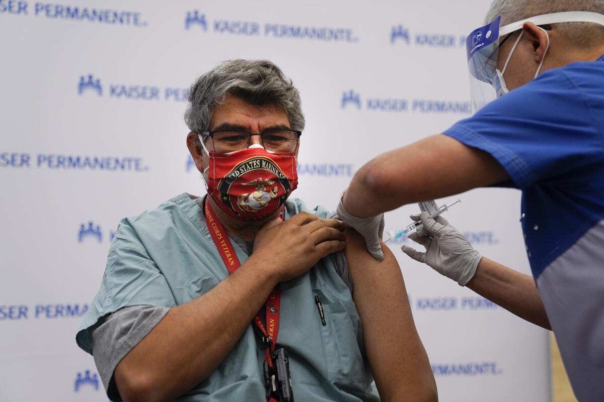 Respiratory care practitioner Raul Aguilar receives the COVID-19 vaccine at Kaiser Permanente Los Angeles Medical Center.
