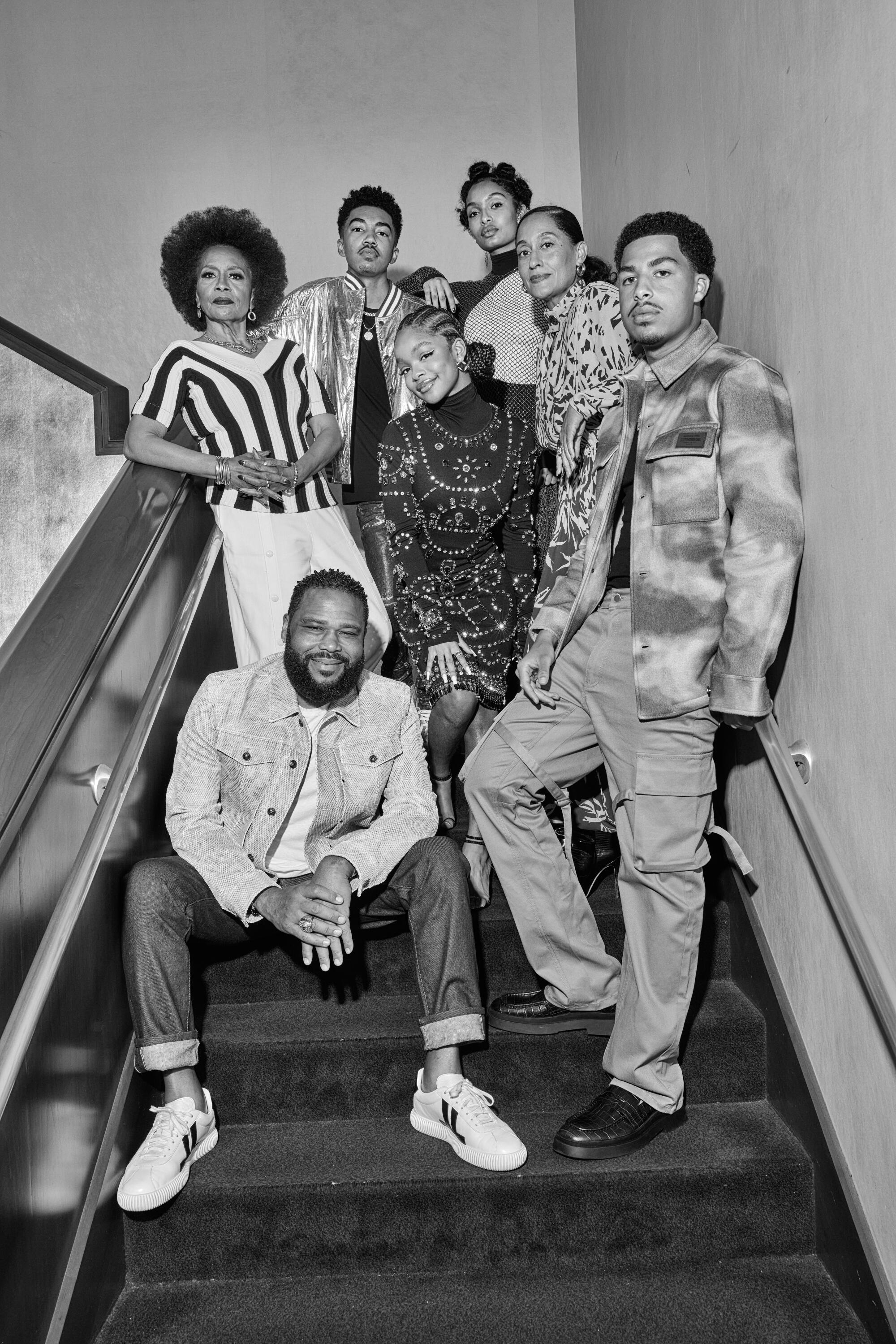 A group of people pose on a staircase.