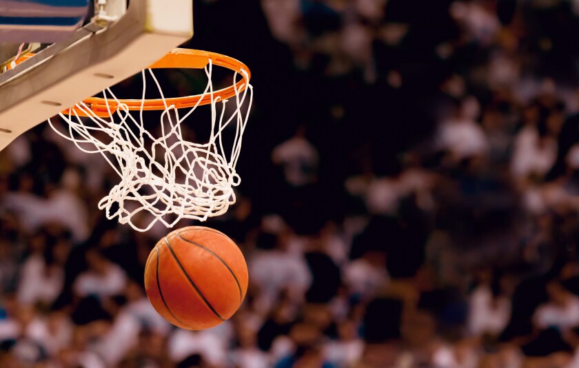 A basketball goes through a hoop