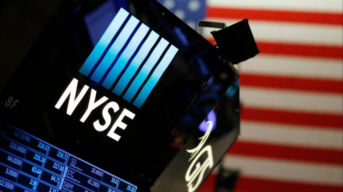 A logo for the New York Stock Exchange is displayed above the trading floor.