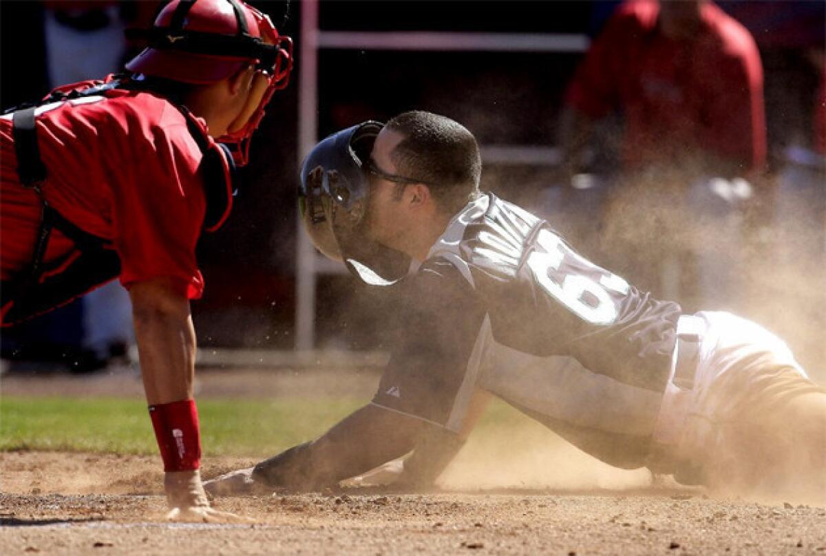 Angels catcher Hank Conger tags out Mariners' Jesus Montero at home plate.