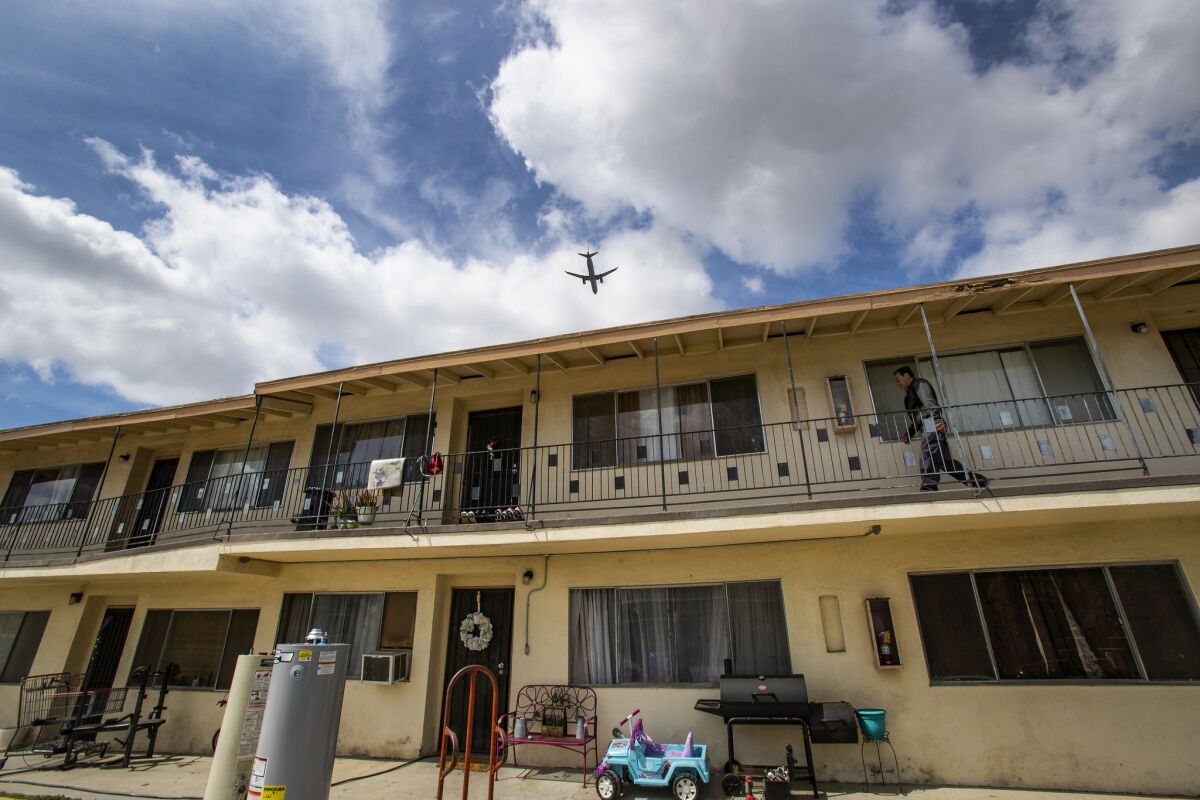 Edgar Sanchez walks to his apartment in the 3700 block of 104th Street in Inglewood as an airplane makes its approach to LAX.