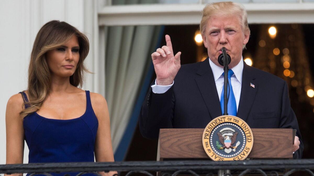 President Trump delivers remarks as First Lady Melania Trump looks on from the Truman Balcony at the White House during a Fourth of July picnic for military families.