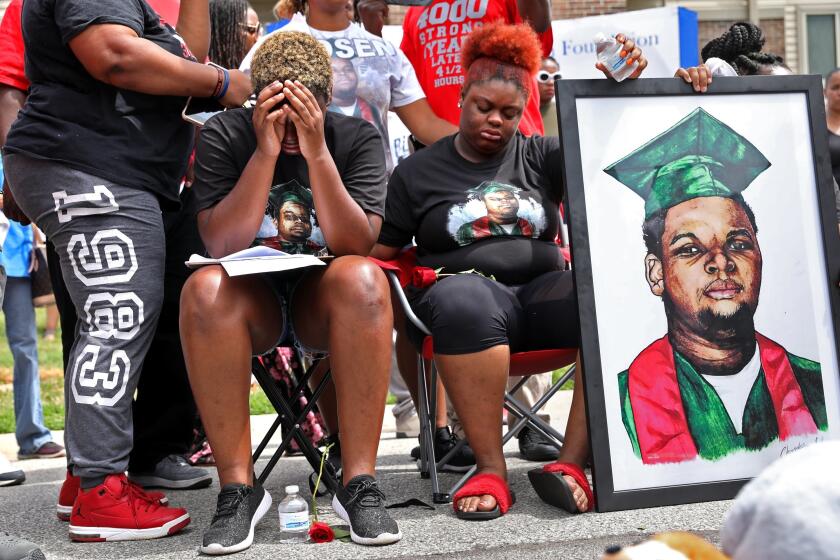 FILE - Trinetta Brown, center left, 19, and Triniya Brown become emotional during a memorial service for their brother, Michael Brown, Thursday, Aug. 9, 2018, in the Canfield Green apartment complex in Ferguson, Mo. St. Louis County's top prosecutor announced Thursday, July 30, 2020, that he will not charge the former police officer who fatally shot Brown. But, he said, "our investigation does not exonerate Darren Wilson." (Cristina M. Fletes/St. Louis Post-Dispatch via AP, File)