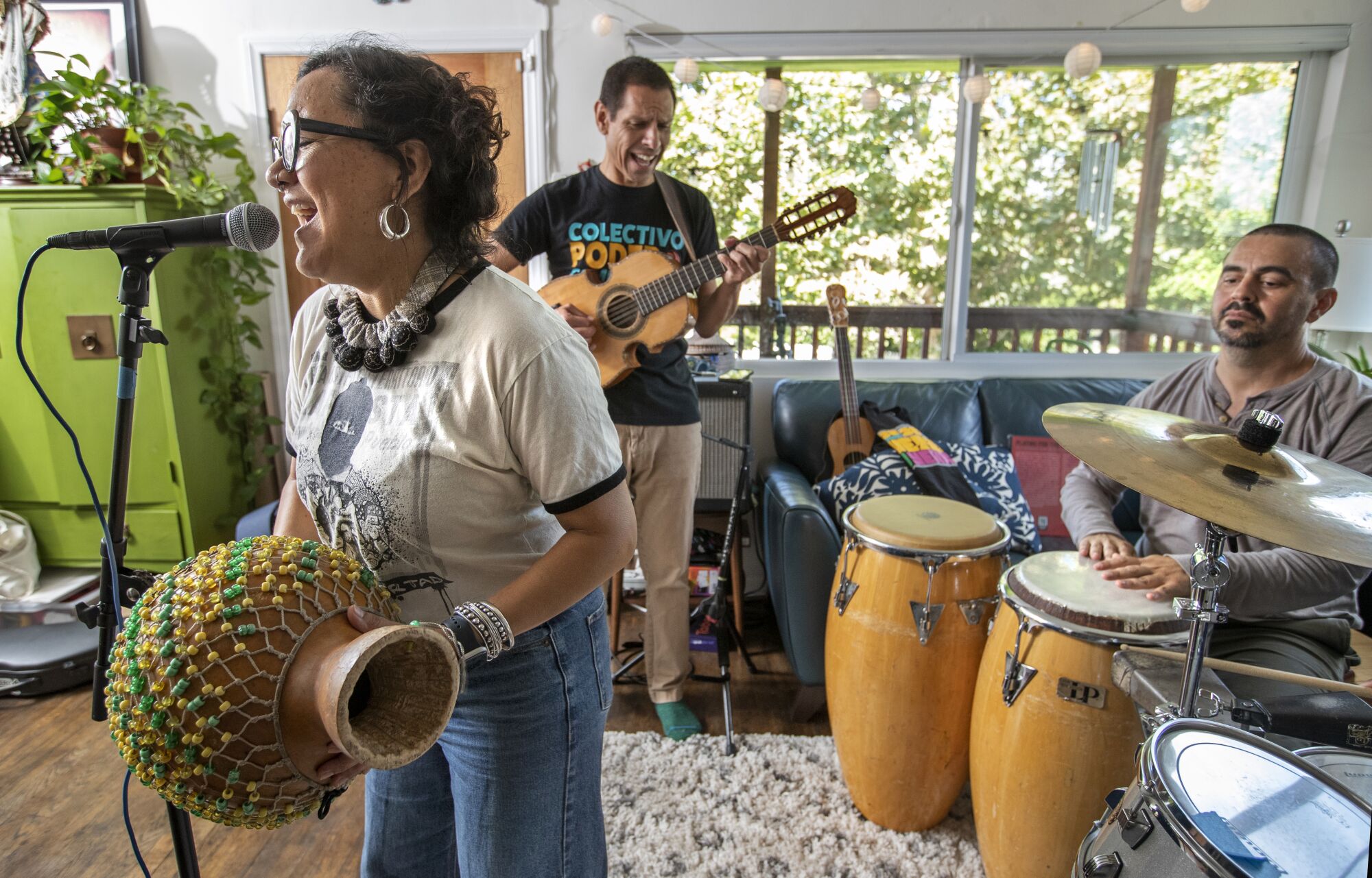 Dr. Martha Gonzalez, left, her husband, Quetzal Flores, center, and Alberto Lopez, members of the band Quetzal, rehearse.