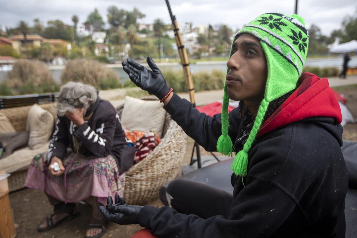 Homeless men David Busch-Lilly, left, and Ayman Ahmed at Echo Park Lake in March 2021.