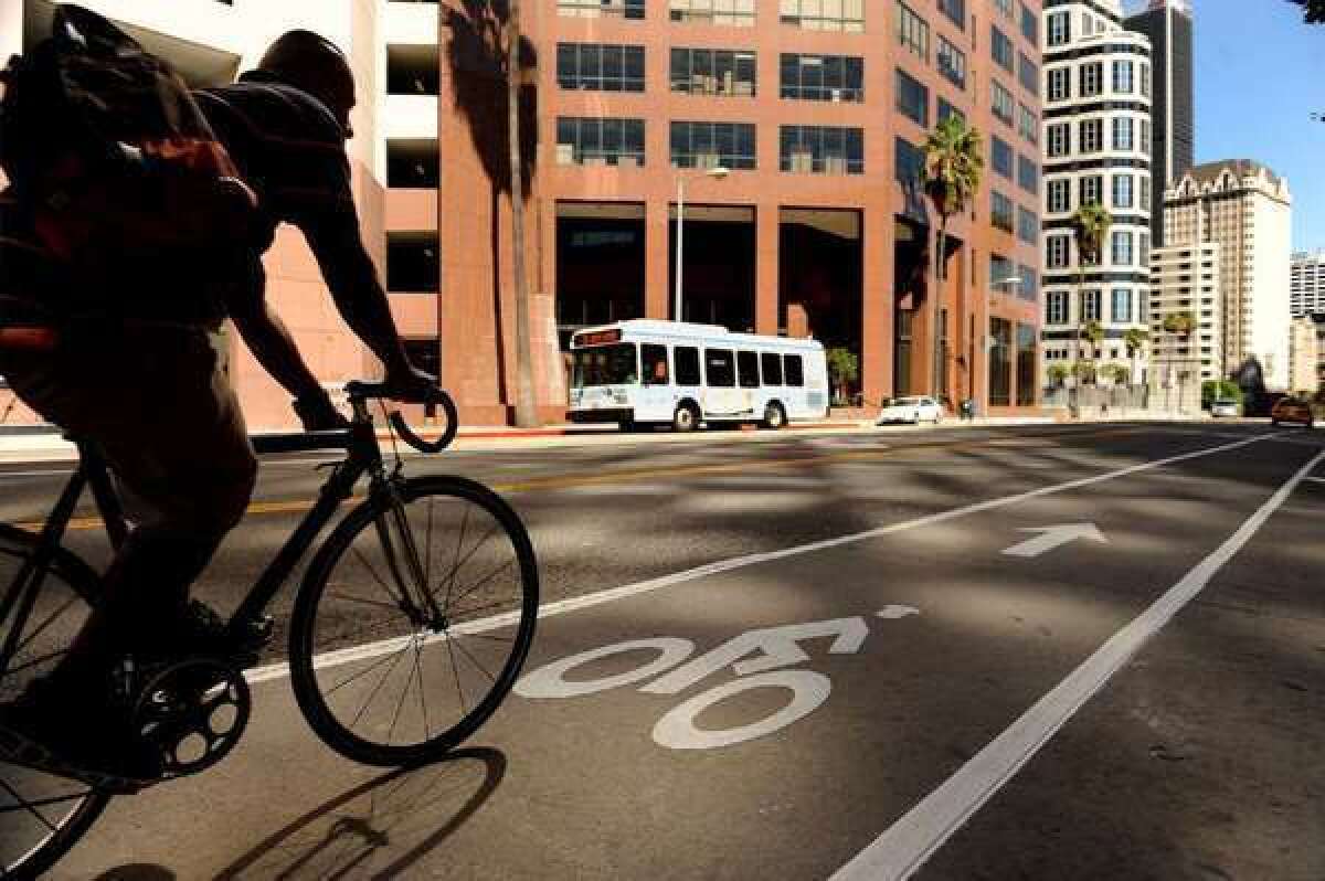 A bicyclist rolls along the bike lane on 7th Street in downtown Los Angeles. The Automobile Club of Southern California reminds bikers to ride in the direction of traffic, not facing it.