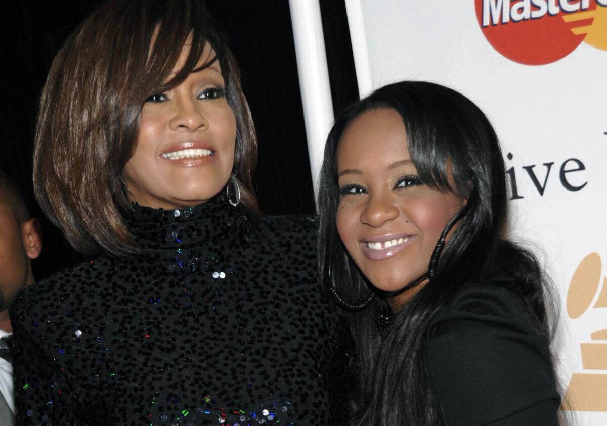 FILE - In this Feb. 12, 2011, file photo, singer Whitney Houston, left, and daughter Bobbi Kristina Brown arrive at an event in Beverly Hills, Calif. Brown is moving to hospice care after months of receiving medical care. Pat Houston says in a statement Wednesday, June 24, 2015, that Whitney Houston's daughter's "condition has continued to deteriorate. Brown was found face-down and unresponsive in a bathtub of her Georgia home earlier this year. She underwent surgery to replace her breathing tube with a tracheostomy tube in February. (AP Photo/Dan Steinberg, File)