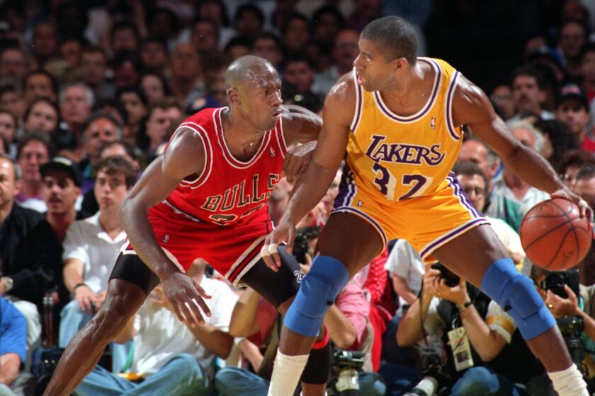 Lakers Earvin Johnson tries to move past Chicagos Bulls Michael Jordan
