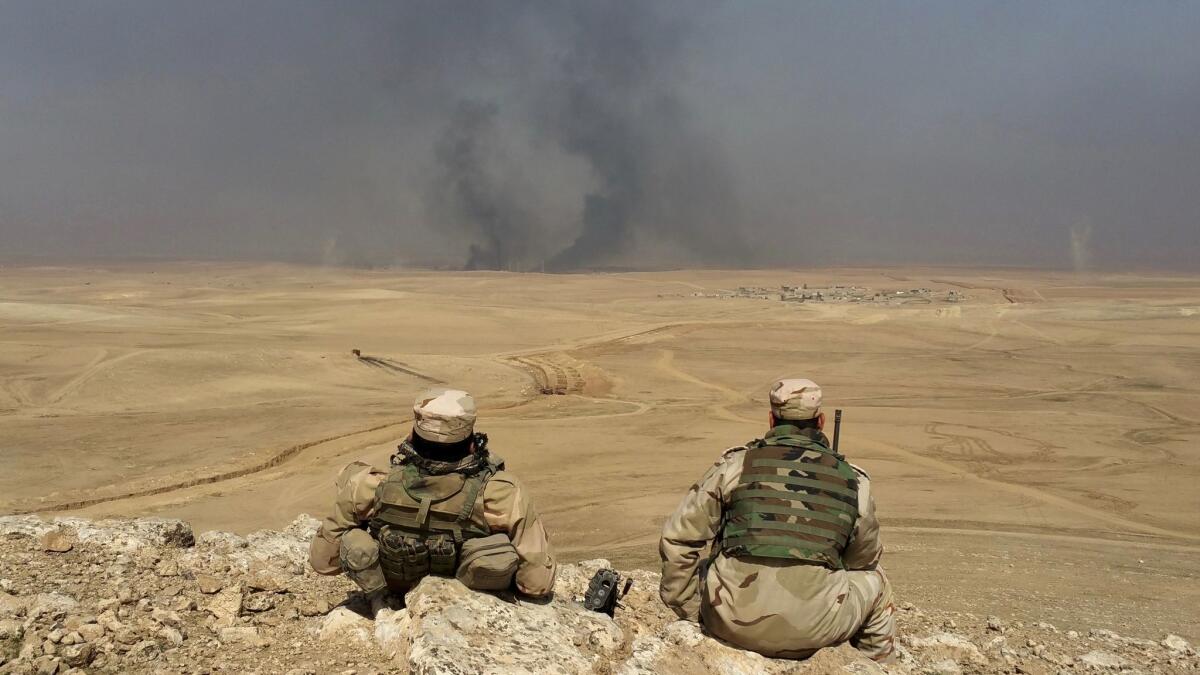 Iraqi soldiers look at the attack on Thaljah village, west of Mosul.