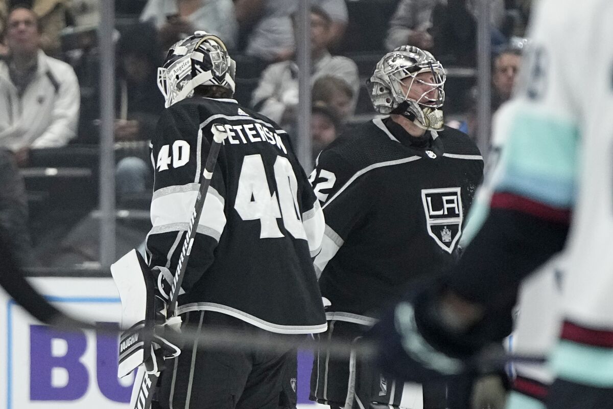 Kings goalies Cal Petersen and Jonathan Quick pass each other as the Kings switch goalies.