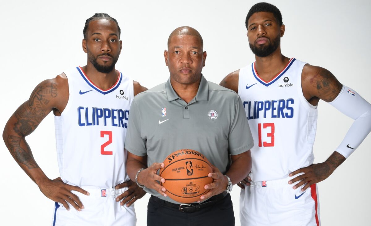 Doc Rivers with his star players Kawhi Leonard (2) and Paul George (13) for a photo shoot during media day.