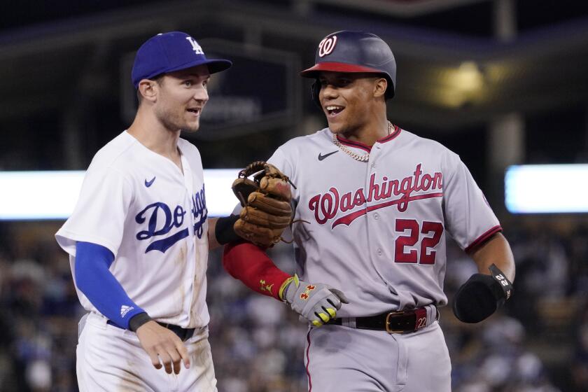 Los Angeles Dodgers' Trea Turner, left, and Washington Nationals' Juan Soto joke around after the end of the top of the seventh inning of a baseball game Monday, July 25, 2022, in Los Angeles. (AP Photo/Mark J. Terrill)