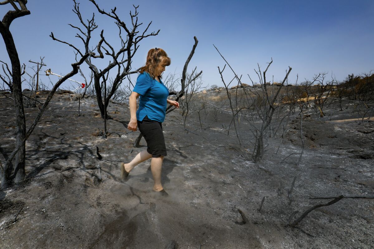Lori Gladfelter inspects her rental home after the Valley fire. 