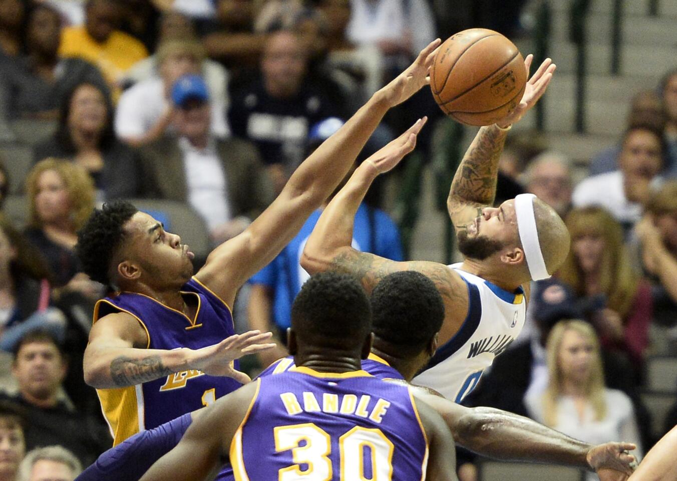 Lakers guard D'Angelo Russell blocks a shot by Mavericks guard Deron Williams in the first half of their game Friday night in Dallas.