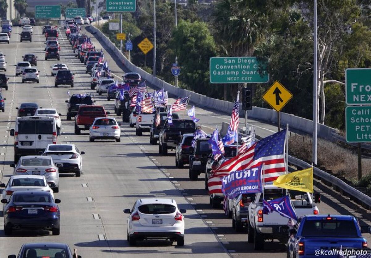 A long line of cars decorated in Trump flags and U.S. flags moves slowly on the freeway.