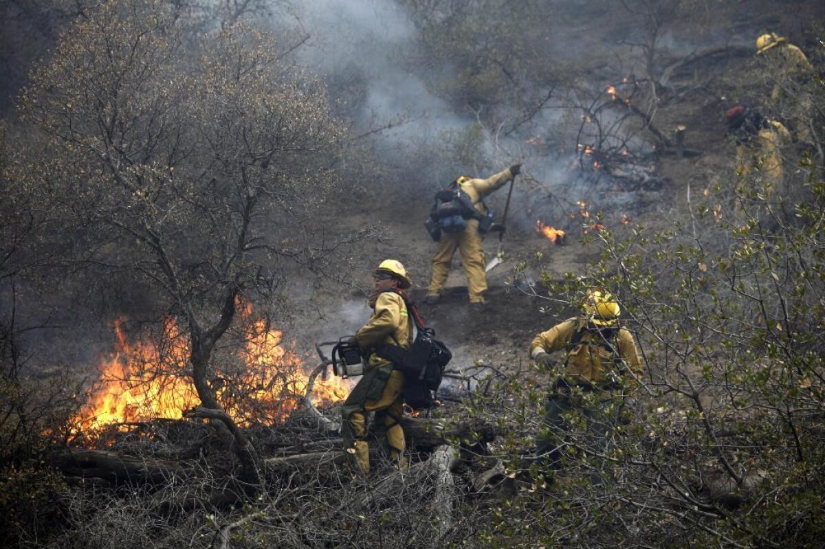 Firefighters battle a 150-acre brush fire south of Highway 138 near Gorman.