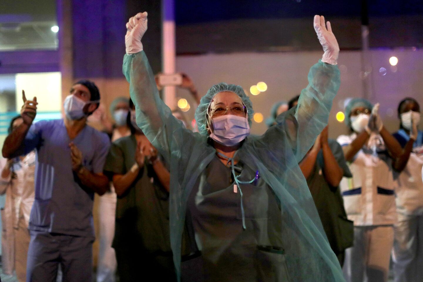 Spain: Health workers react as people applaud from their houses in support of the medical staff working on the coronavirus outbreak in Madrid.