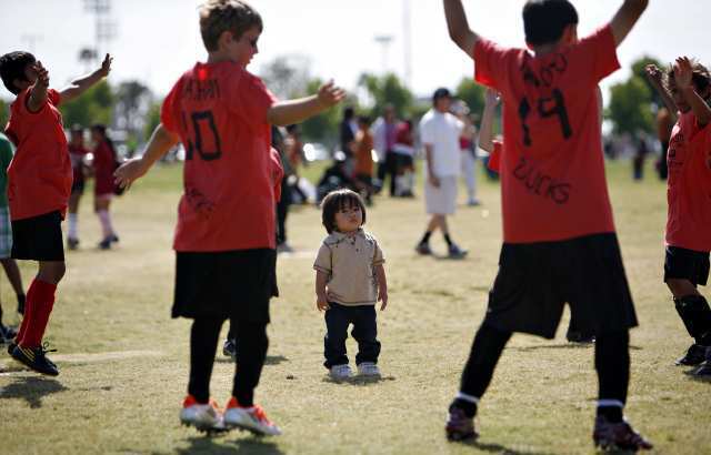 Kapono Casperson watches as Davis Magnet School soccer players warm up during the Daily Pilot Cup on Thursday.