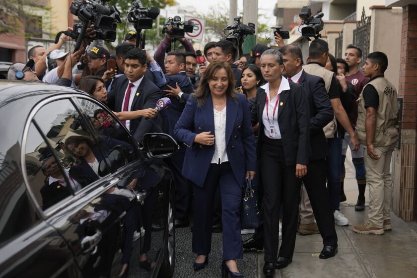 Peru's new President Dina Boluarte walks to her car after speaking to the press as she leaves her home in Lima, Peru, early Thursday, Dec. 8, 2022. Peru's Congress voted to remove President Pedro Castillo from office Wednesday and replace him with the vice president, shortly after Castillo tried to dissolve the legislature ahead of a scheduled vote to remove him. (AP Photo/Martin Mejia)