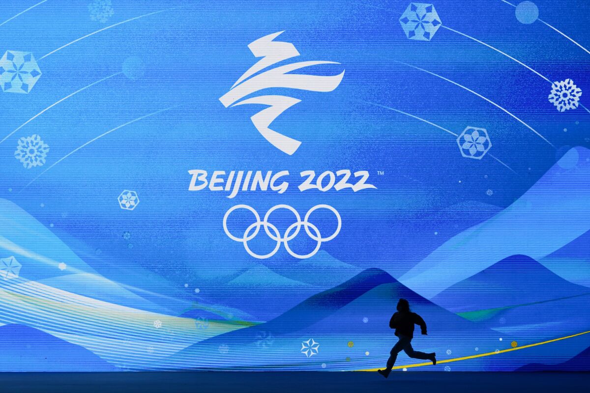 A performer runs across the stage during a rehearsal for the medal ceremonies ahead of the 2022 Winter Olympics, Tuesday, Feb. 1, 2022, in Beijing. (AP Photo/Jae C. Hong)