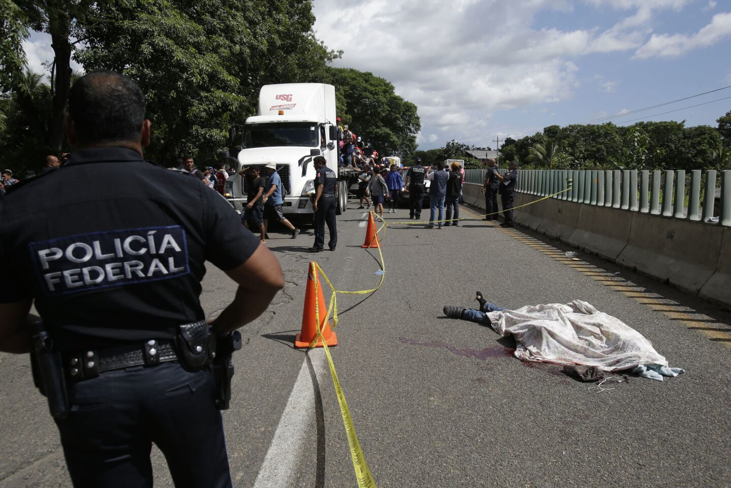 A Central American migrant, who fell from the back of a moving vehicle and died, lies on a highway outside of Tapachula, Mexico.