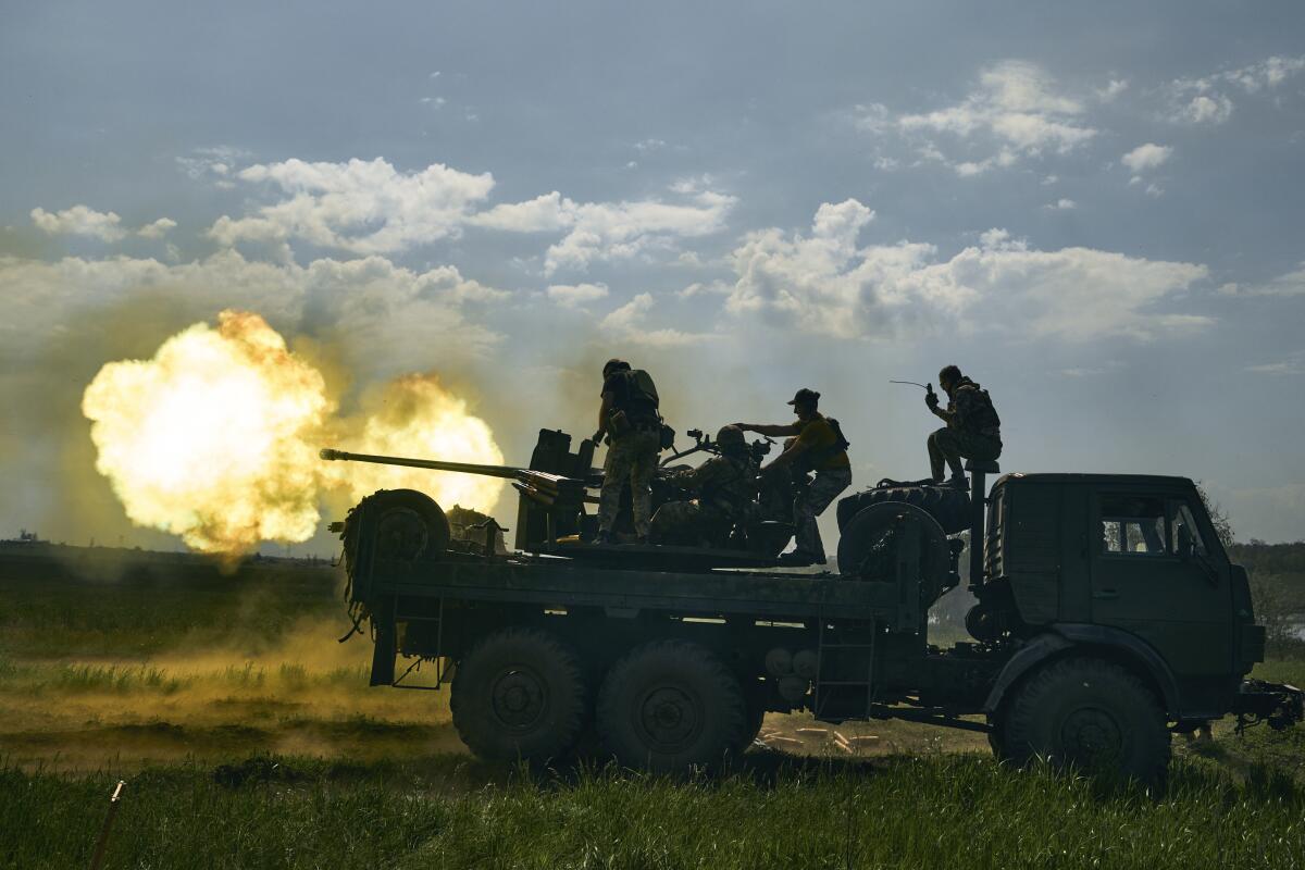 ARCHIVO - Soldados ucranianos disparan un cañón cerca de Bájmut, una ciudad oriental 