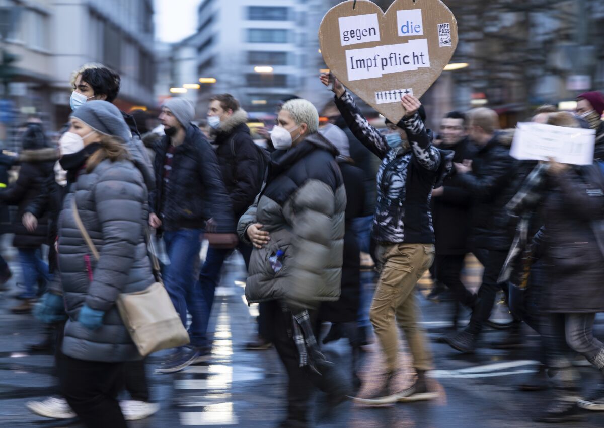 A participant holds a banner in a demonstration against COVID-19 measures and compulsory vaccination, with a sign reading "Against compulsory vaccination." on Jan. 8, 2022, in Frankfurt, Germany. (Hannes P. Albert/dpa via AP)