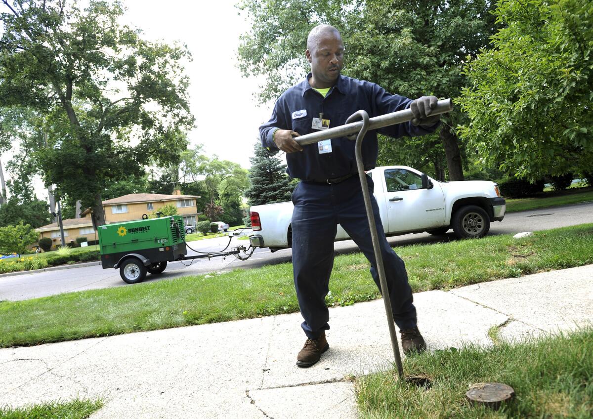 Detroit city worker Chester Clemons shuts off the water at a home in the Palmer Woods neighborhood on July 8. State-appointed emergency manager Kevyn Orr on July 29 shifted control of Detroit's water department to Mayor Mike Duggan.