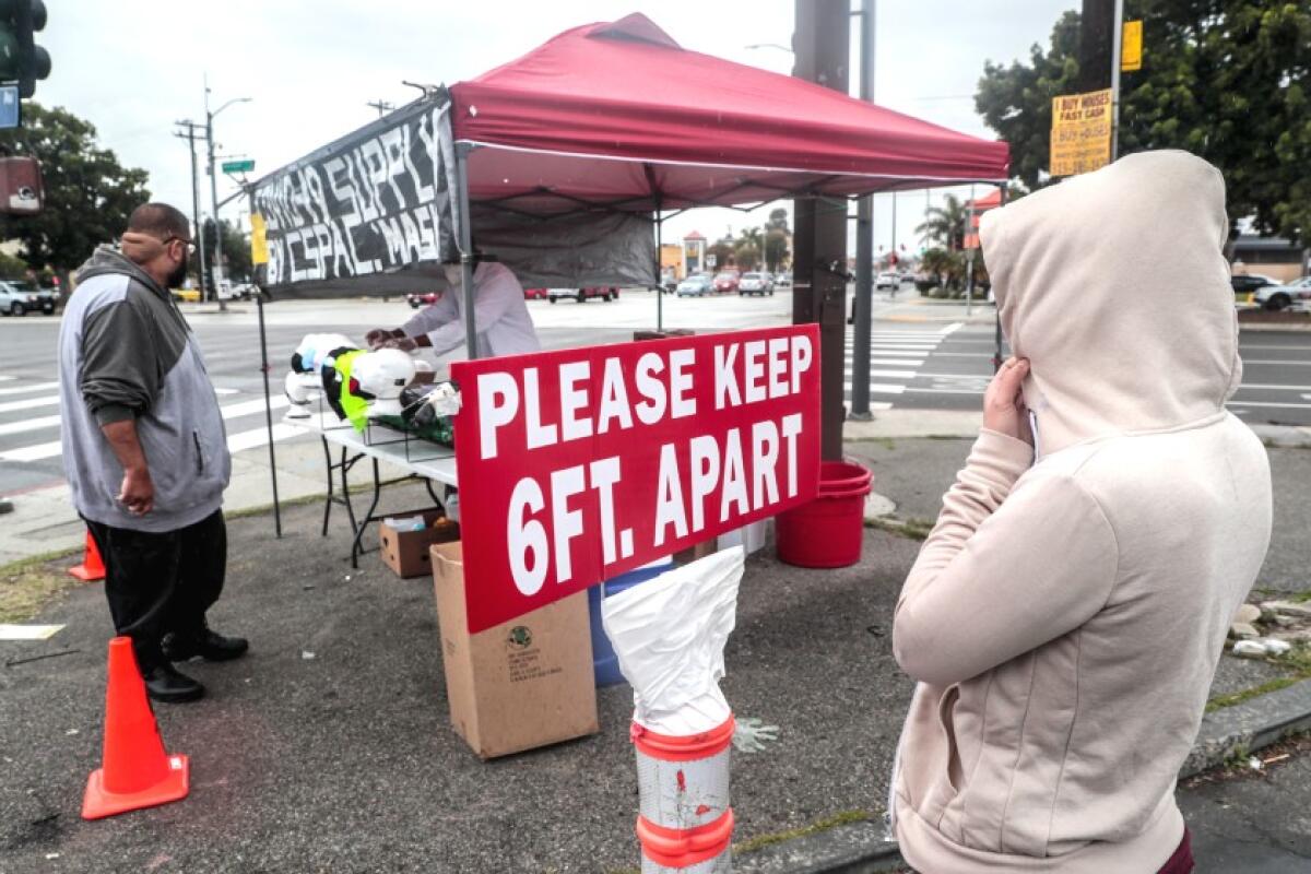 A sign urging people to stay six feet apart on a vendor's stand.