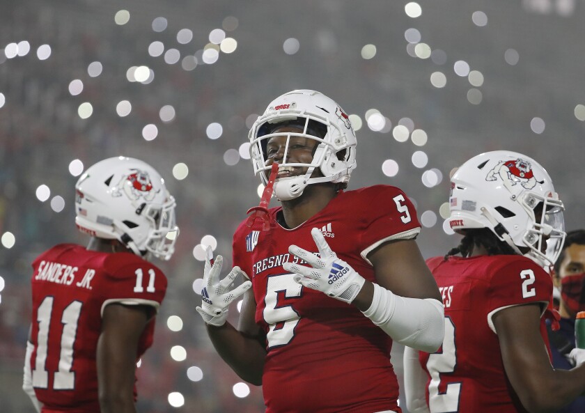 Fresno State defensive end Devo Bridges signals the fourth quarter in the team's NCAA college football game in Fresno, Calif., Saturday, Nov. 13, 2021, as fans turn on the lights on their phones. (AP Photo/Gary Kazanjian)