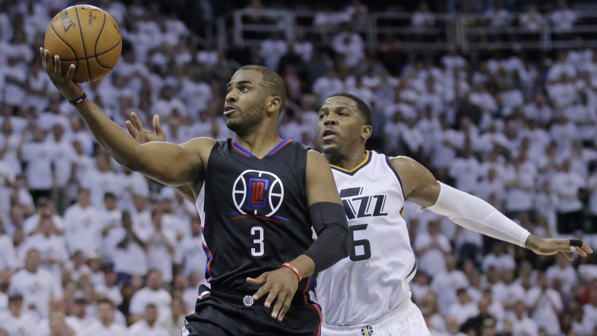 Clippers point guard Chris Paul lays the ball up against Jazz forward Joe Johnson during the first half Sunday.
