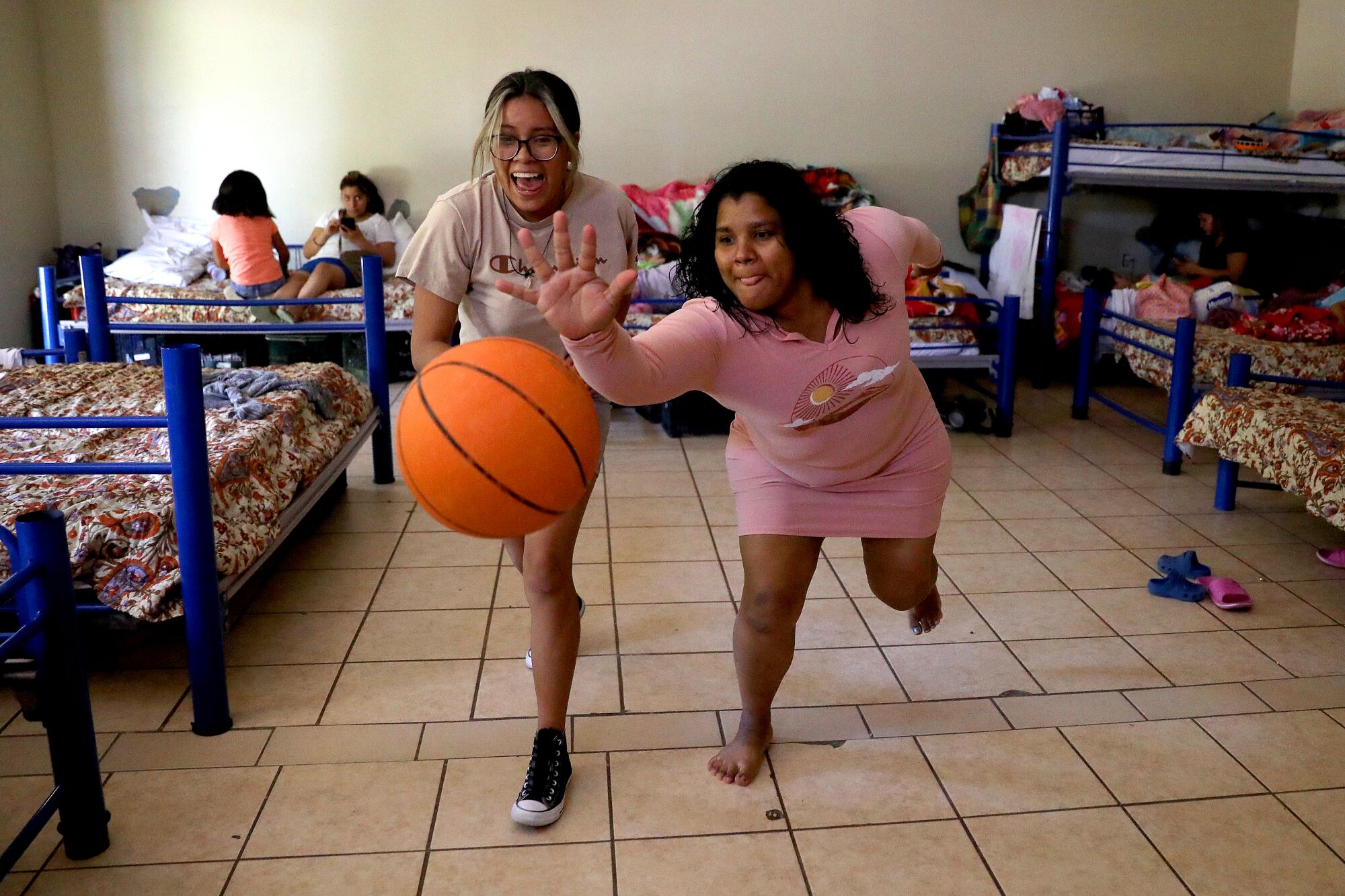  Jennifer Angel Constancio, 15, left, of Michoacan, Mexico, and Duria Romero, 32, of Honduras, play a game of keep a way .