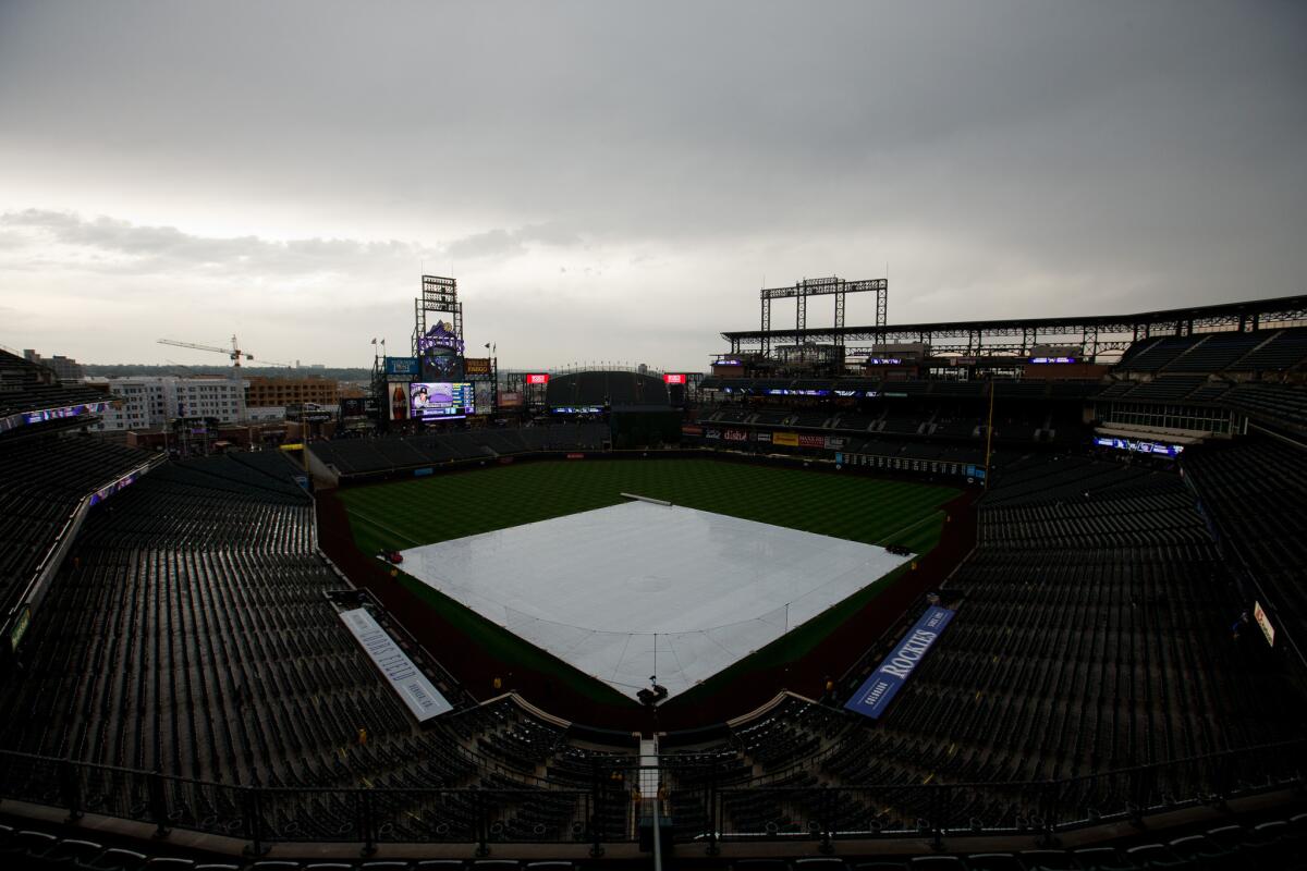 Rain falls before a game Sunday between the Dodgers and the Colorado Rockies at Coors Field in Denver.