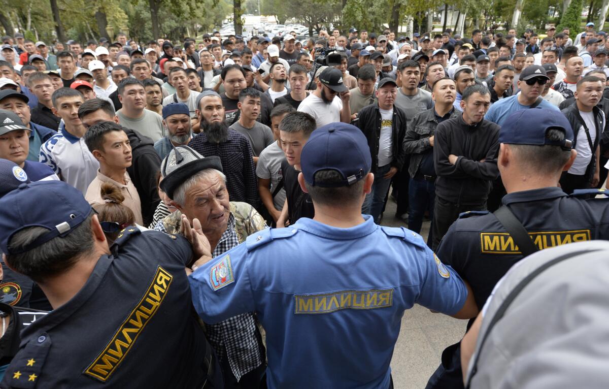 Kyrgyz volunteers gather outside the government building demanding they be sent to the conflict zone at the Kyrgyz-Tajik border, in Bishkek, Kyrgyzstan, Friday, Sept. 16, 2022. Kyrgyzstan and Tajikistan on Friday agreed to a cease-fire on a shared border where clashes earlier in the day wounded 42 people. (AP Photo/Vladimir Voronin)