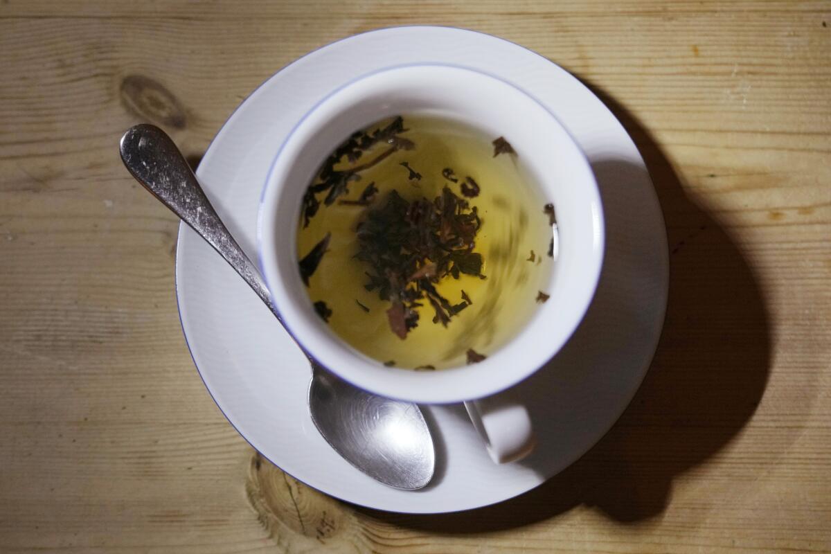 A cup of tea with a spoon.