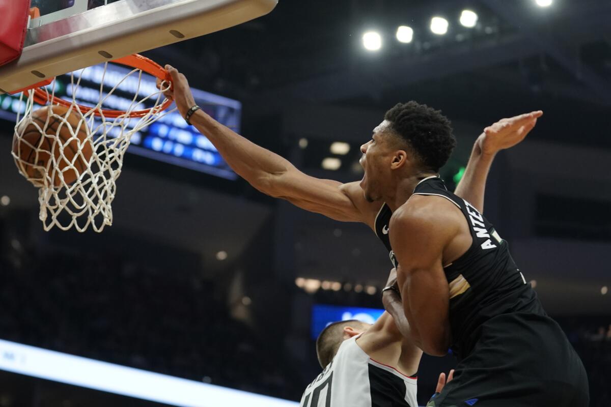The Bucks' Giannis Antetokounmpo dunks on the Clippers' Ivica Zubac during the second half.