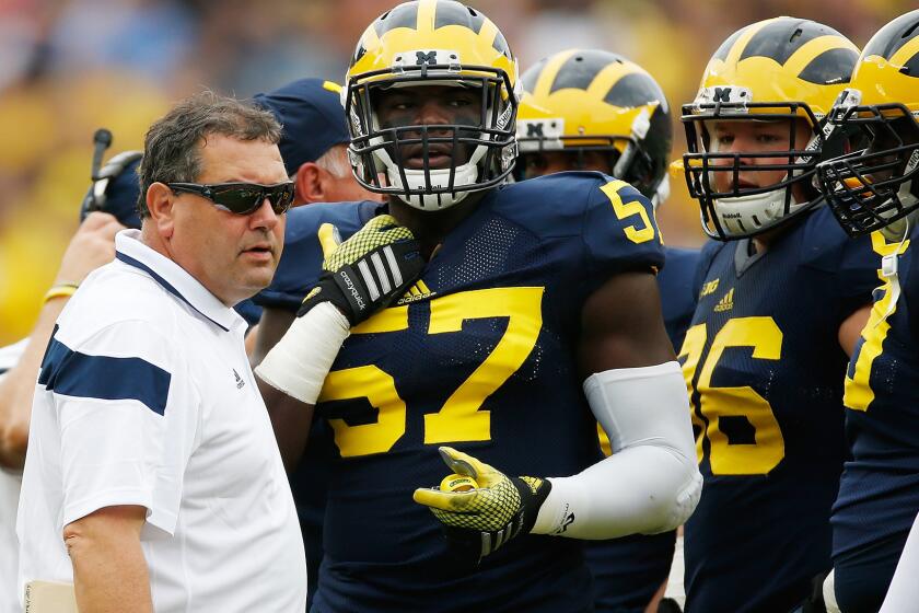 Michigan Coach Brady Hoke talks with his players during a loss to Utah on Sept. 20. The Wolverines' 2-3 record is only one of the problems threatening Hoke's tenure in Ann Arbor.