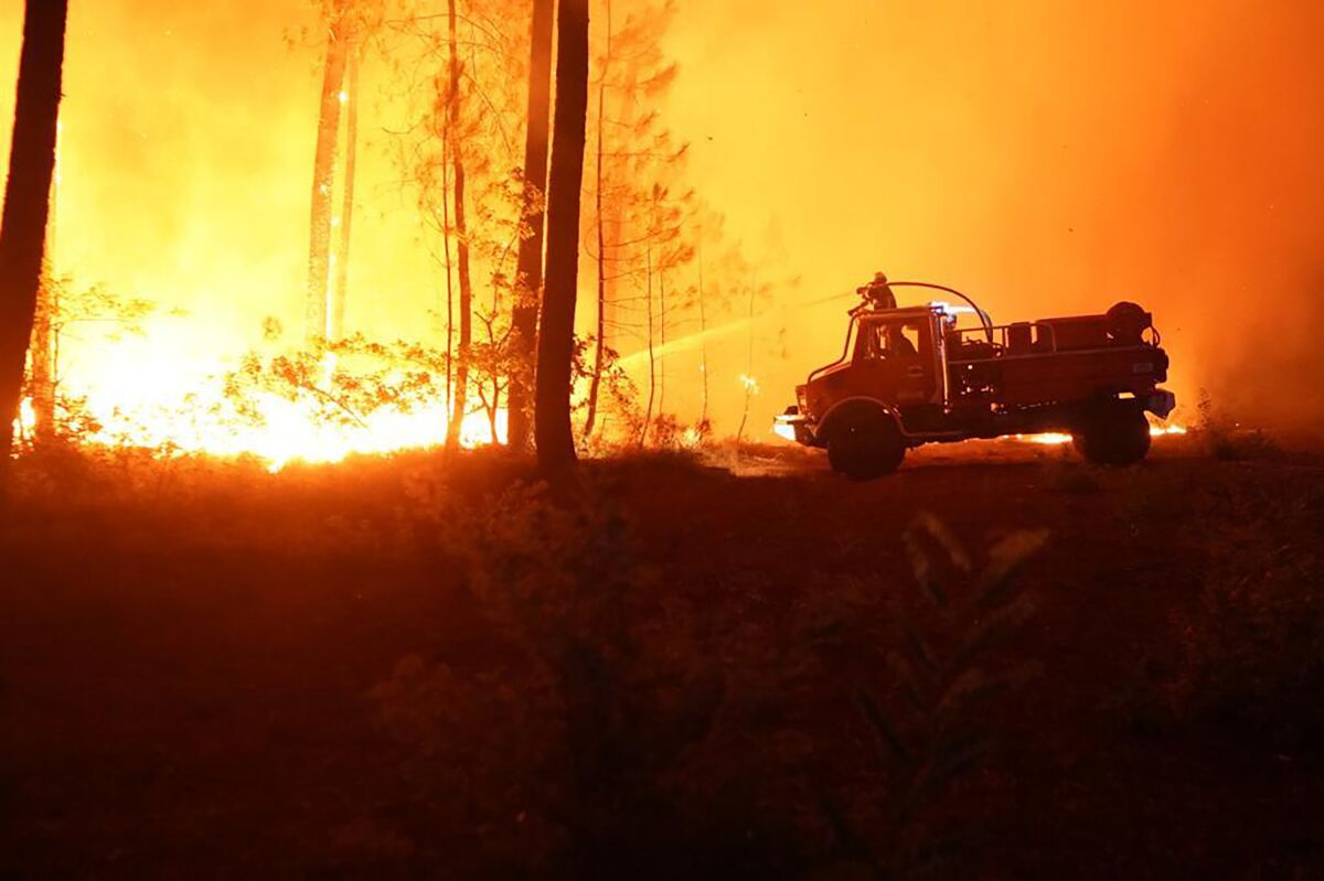 En esta imagen cortesía de la brigada contra incendios SDIS 33 de Gerona, bomberos combaten un incendio el miércoles 10 de agosto de 2022, al sur de Burdeos, en el suroeste de Francia. (SDIS 33 via AP)
