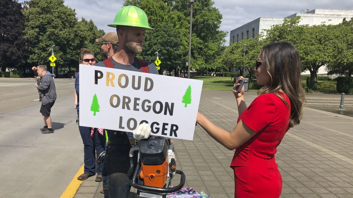 A TV reporter interviews self-employed logger Bridger Hasbrouck outside the Oregon State Capitol in Salem on Thursday.