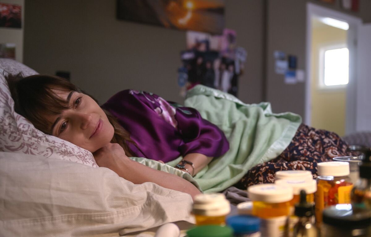 Linda Cardellini, lying in bed and smiling, in a scene from Netflix's "Dead to Me"